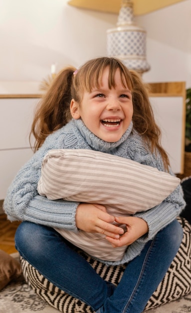 Free photo smiley girl hugging pillow