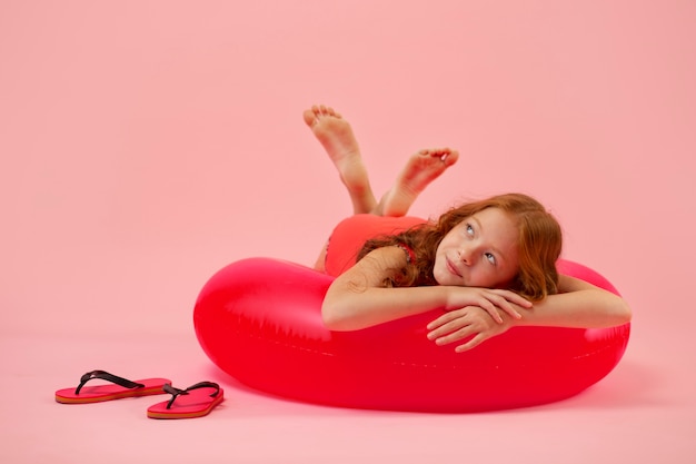 Free photo smiley girl laying on red lifeline full shot