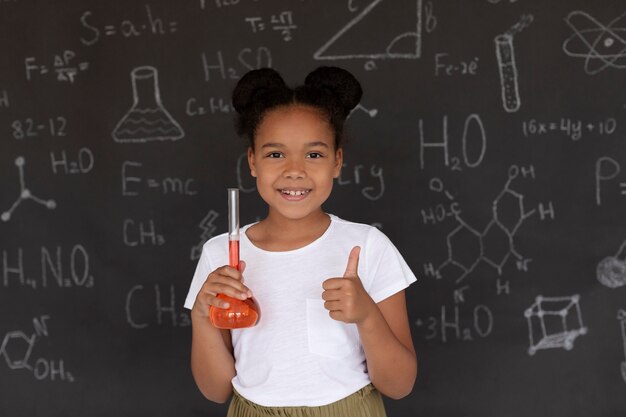 수업 시간에 화학에 대해 더 많이 배우는 웃는 소녀