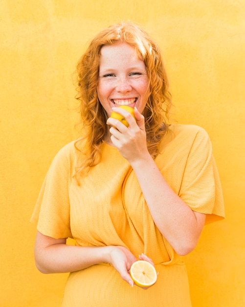 Smiley girl licking lemon