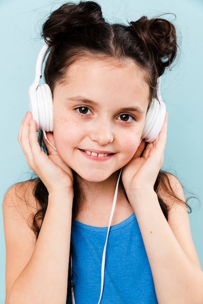 Smiley girl listening music at headphones