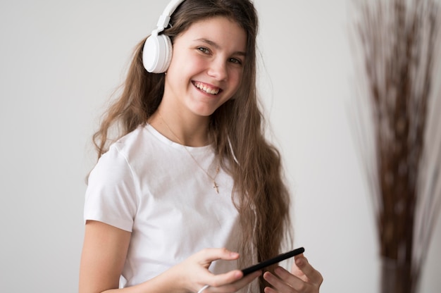 Smiley girl listening music at headphones