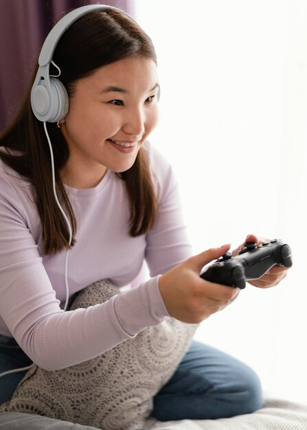 Smiley girl playing videogame in bed