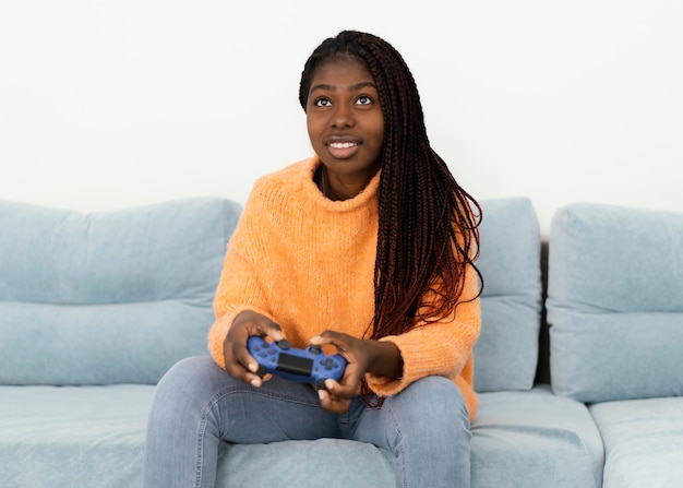 Smiley girl playing videogame medium shot