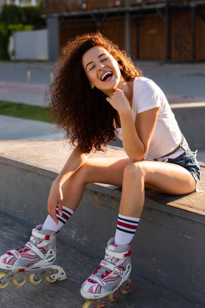 Foto gratuita ragazza di smiley che propone in rollerblades all'esterno