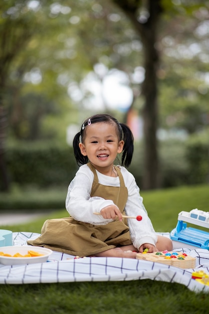 Smiley girl sitting on cloth full shot