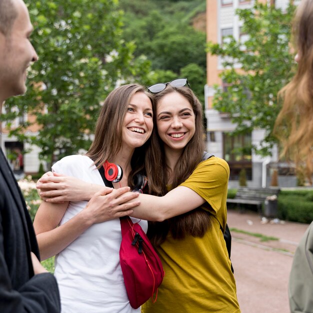 Smiley girlfriends hugging