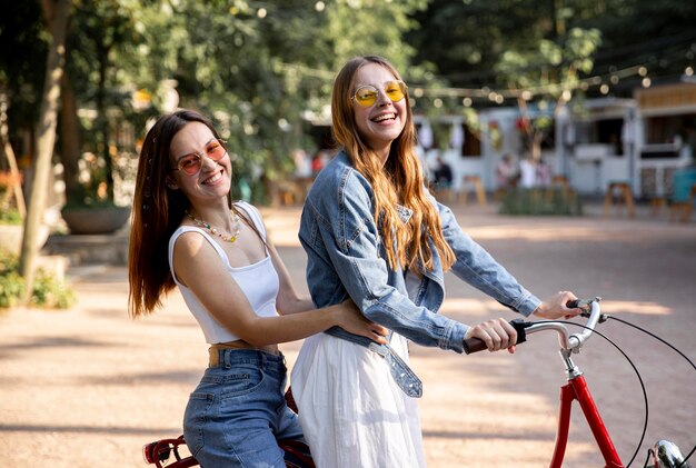 Smiley girlfriends riding bike together