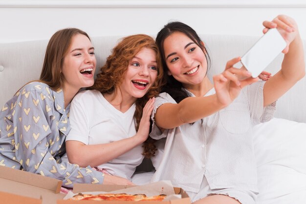 Smiley girlfriends taking selfies