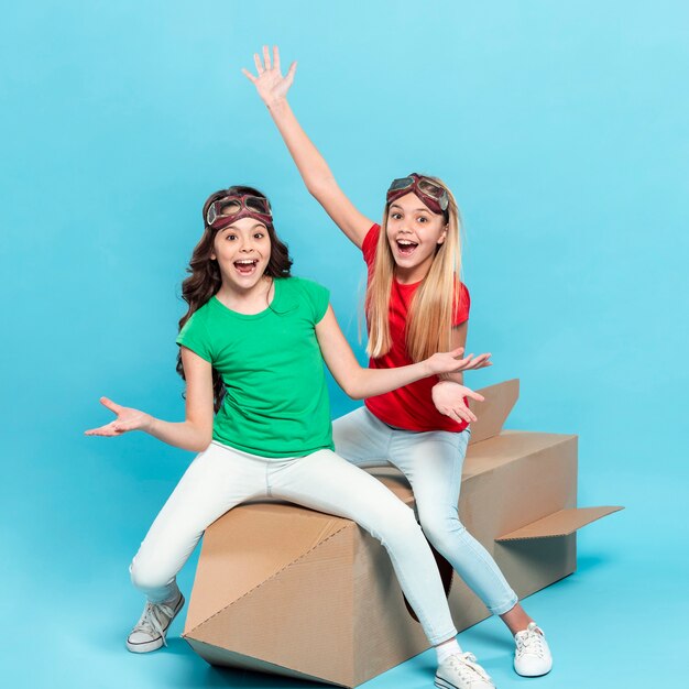 Smiley girls sitting on cartoon flying ship