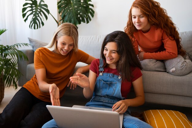 Smiley girls sitting indoors high angle