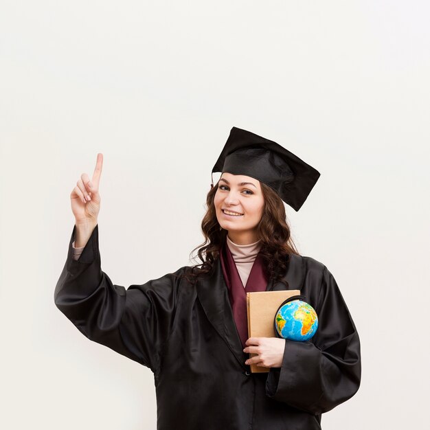 Smiley graduate holding globe