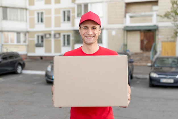 Free photo smiley guy delivering package
