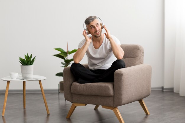 Smiley guy sitting on a chair and listening to music