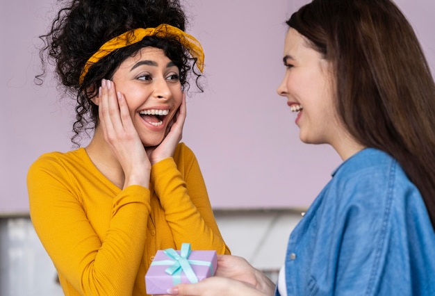 Smiley happy women giving each other gifts