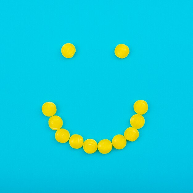 Smiley jelly candies on blue table 