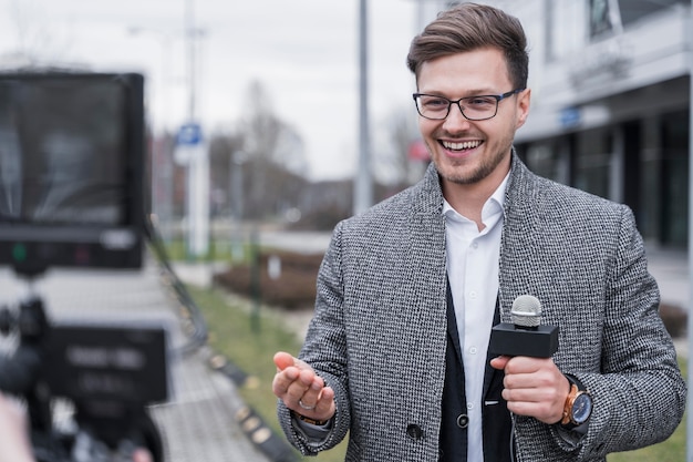 Free photo smiley journalist filming