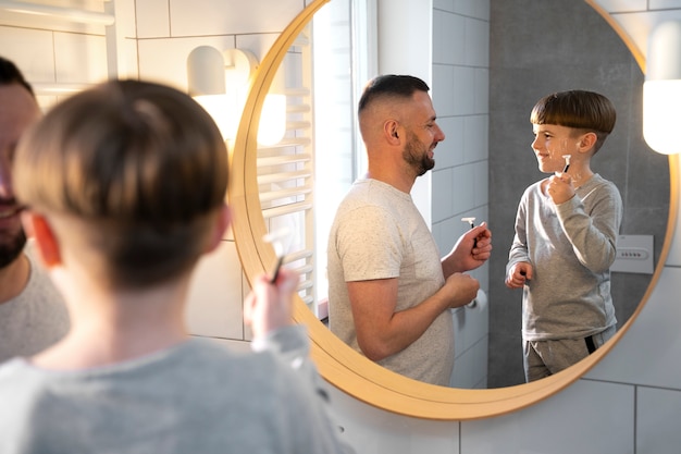 Smiley kid and father in bathroom