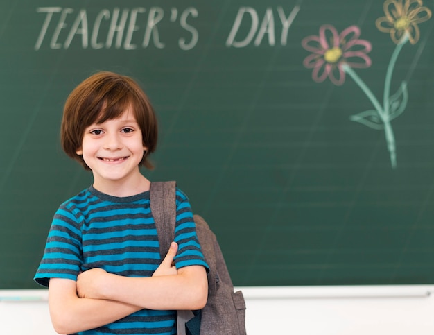 Smiley kid posing next to blackboard