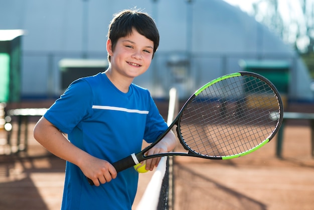 Smiley kid resting on tennis net
