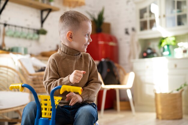 Smiley kid with tricycle indoors