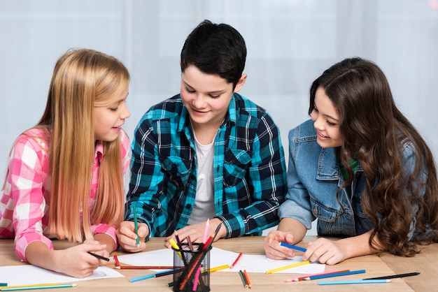 Smiley kids at table coloring