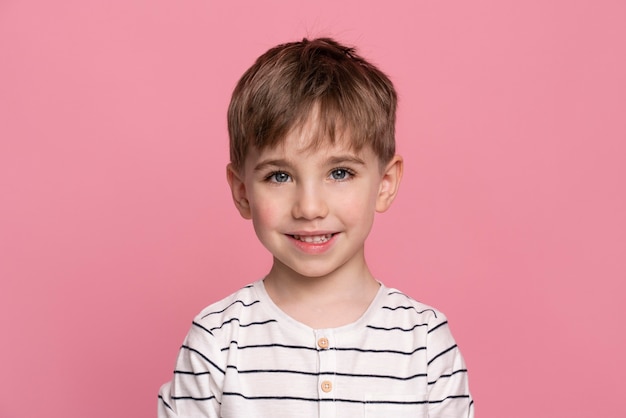 Smiley little boy isolated on pink