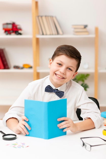 Free photo smiley little boy reading