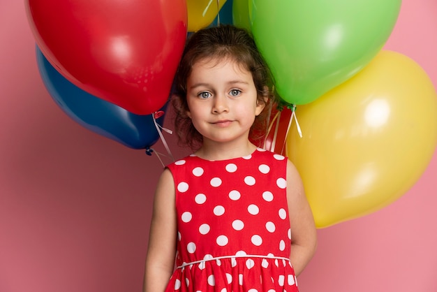 Foto gratuita bambina di smiley in un vestito rosso che celebra il suo compleanno