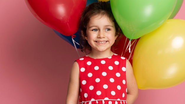 Smiley little girl in a red dress celebrating her birthday