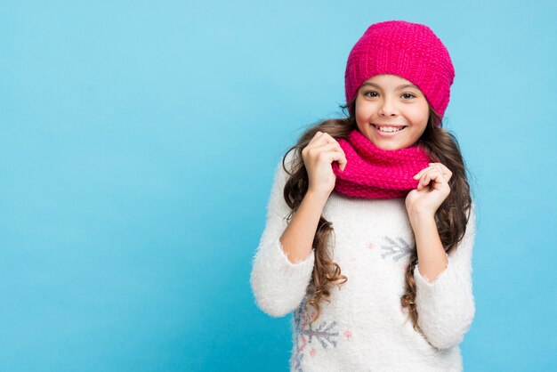 Улыбающаяся маленькая девочка в шляпе и шарфе