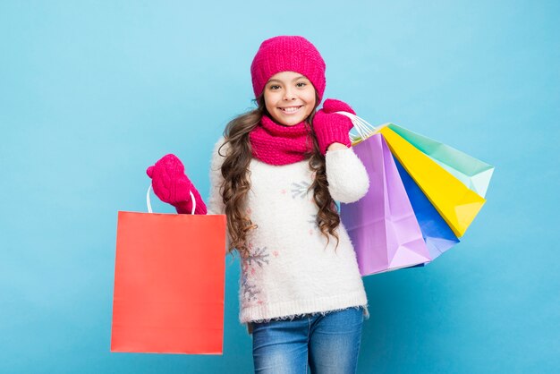 Smiley little girl with winter clothing bags