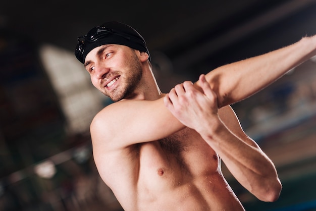 Smiley male swimmer stretching