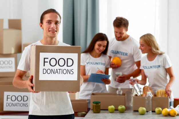 세계 식량의 날에 대한 조항과 함께 웃는 남성 자원 봉사 지주 상자