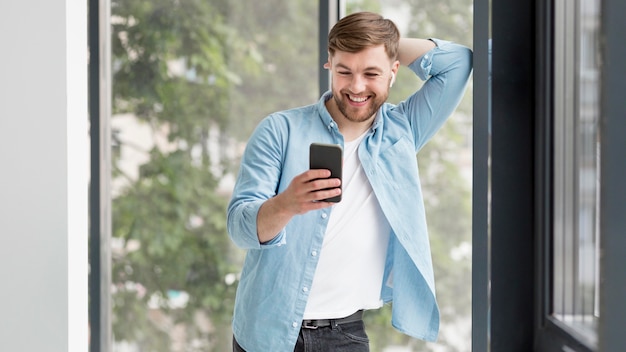 Smiley man checking mobile