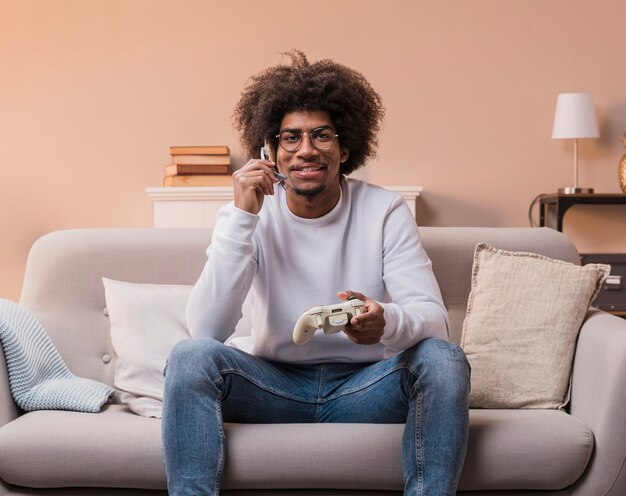 Smiley man on couch playing games
