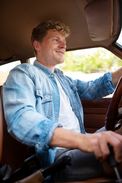 Foto gratuita uomo sorridente che guida un'auto inquadratura media