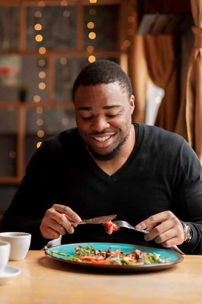 Smiley man eating at restaurant