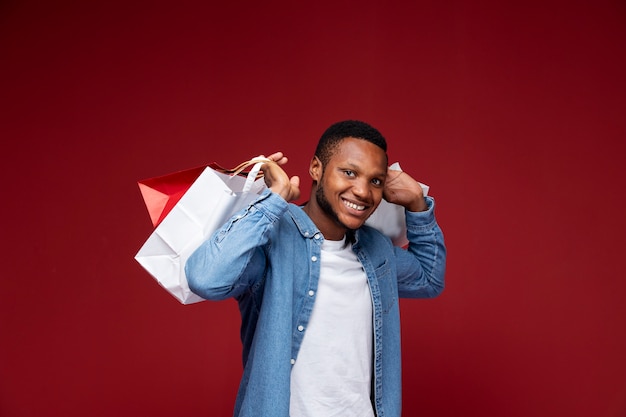 Free photo smiley man holding bags medium shot