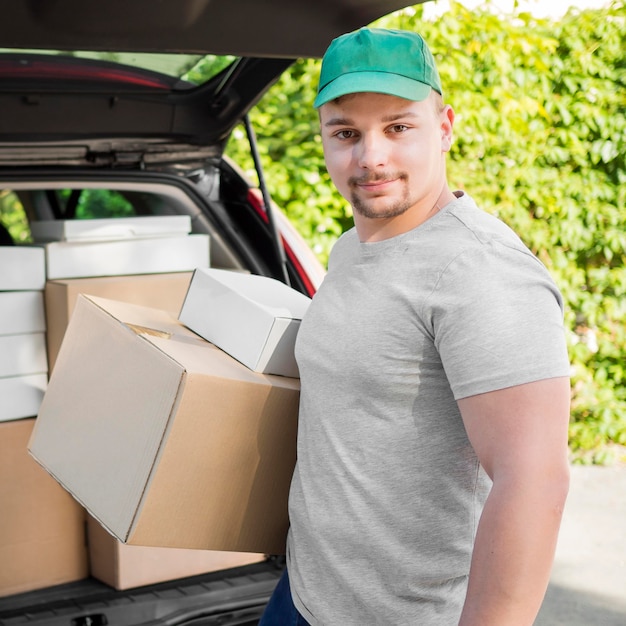 Free photo smiley man holding boxes