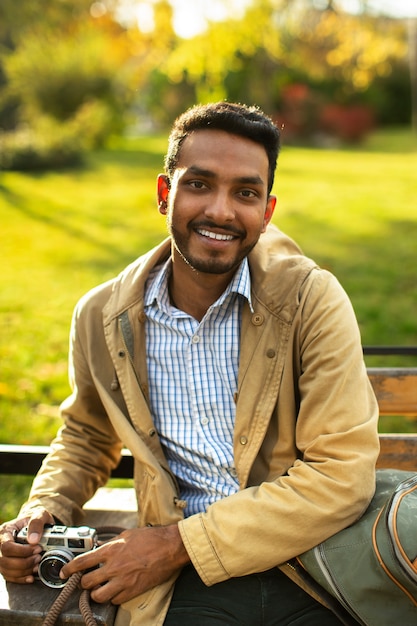 Free photo smiley man holding camera front view