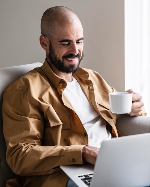 Free photo smiley man holding coffee cup