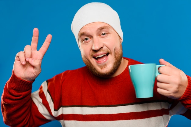 Free photo smiley man holding a cup of coffee