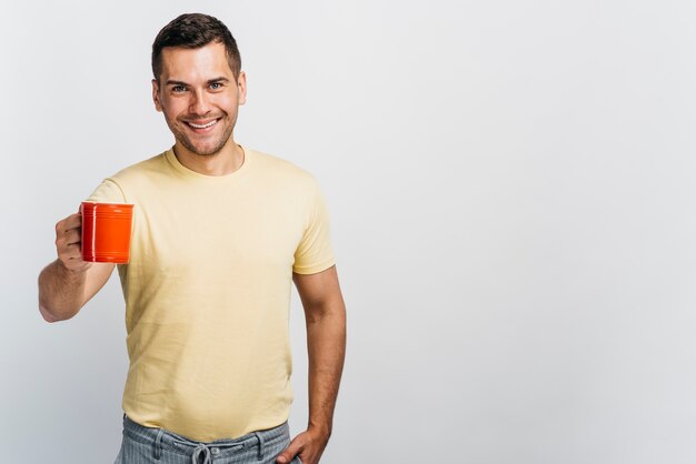 Smiley man holding a cup with copy space