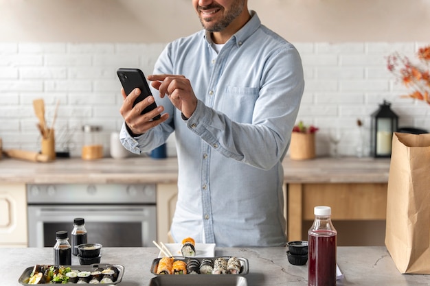 Foto gratuita uomo sorridente che tiene la vista laterale dello smartphone