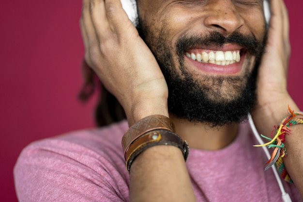무료 사진 헤드폰을 통해 음악을 듣고 웃는 남자