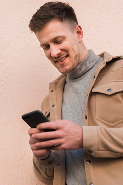 Uomo di smiley che esamina smartphone