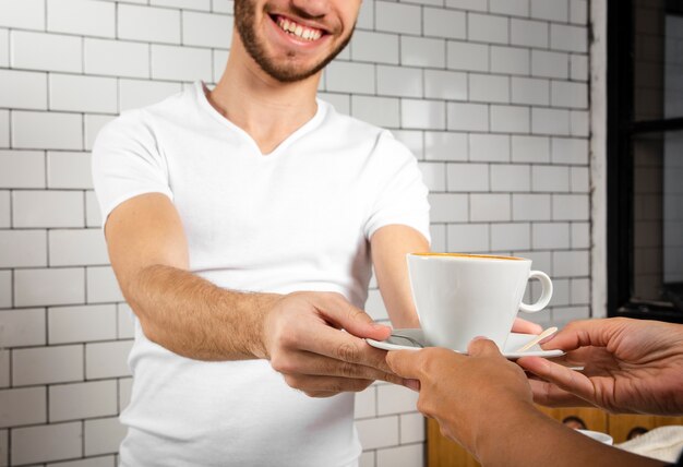 Smiley man  offering a cup of coffee