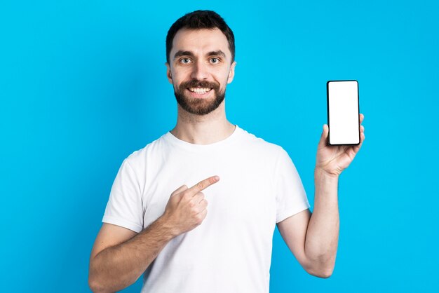 Smiley man pointing at smartphone
