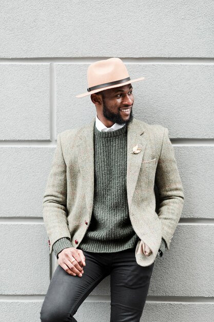 Smiley man posing on a grey wall